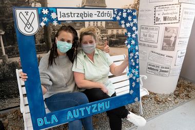 Pracownice MOK-u trzymają drewnianą, niebieską ramkę z napisem "dla autyzmu"