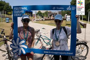 Uczestnicy rajdu rowerowego na OWN odbierają medale i robią pamiątkowe zdjęcia.