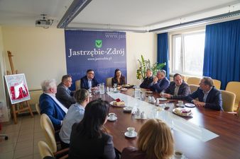 Ujęcie szerokie, uczestnicy spotkania siedzą przy stole