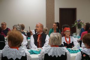 Publiczność zebrana w salce przy stołach