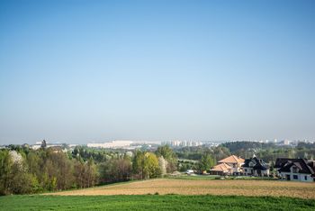 Pola, drzewa i domy, a w oddali bloki w Jastrzębiu-Zdroju