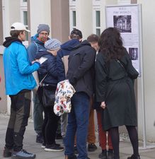Uczestnicy gry terenowej zgromadzenie wokół tablicy z napisem Muzeum Pamięć Historyczna