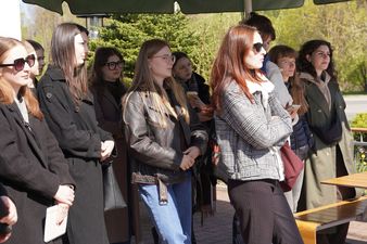 Studenci stojacy pod parasolem