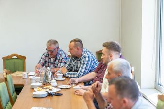 6 mężczyzn siedzi przy stole konferencyjnym
