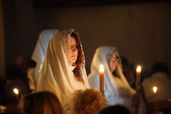 kobiety w białych szatach trzymające świece