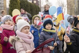 Dzieci w wieku przedszkolnym z chorągiewkami polskimi i ukraińskimi na placu WOŚP.
