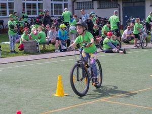 Dziewczynka mijajaca pachołek na boisku. 
