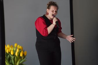 kobieta w czarno-czerwonym stroju śpiewa