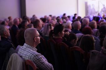 widok z tyłu na tłum widzów siedzących przed sceną