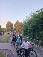 Grupa ludzi jedzie przed siebie na rowerach