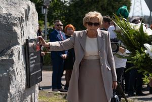 Wdowa po Tadeuszu Jedynaku przed tablica upamiętniającą jego osobę.