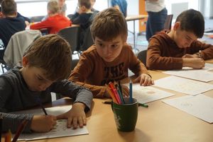 Grupka dzieci rysuje 