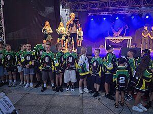 Dzieci w sportowych koszulkach GKS Jastrzębie stoją przed sceną podczas prezentacji
