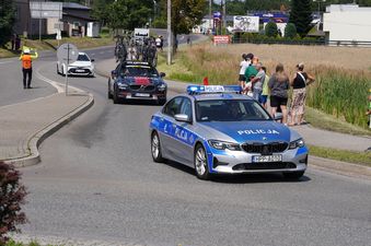 Konwój samochodów technicznych z samochodem policji