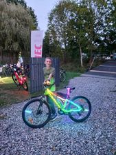 Chłopak stoi ze świecącym rowerem