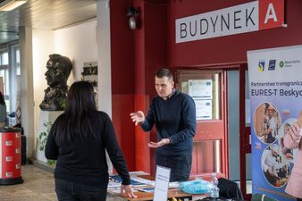 Mężczyzna, wystawca rozmawiający z uczestniczką targów.