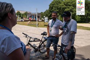 Uczestnicy rajdu rowerowego na OWN odbierają medale i robią pamiątkowe zdjęcia.