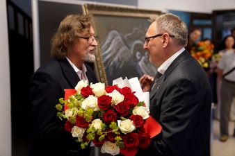 Dyrektor muzeum Jędrzej Lipski wręcza bukiet kwiatów Janowi Marii Tomaszewskiemu