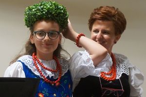 dziewczynka w stroju ludowym wkłada wianek