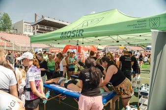 zawodniczki pod zielonym namiotem są masowane po biegu