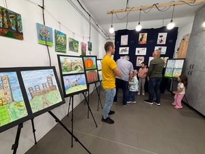 uczestnicy wernisażu oglądają wystawę na pierwszym planie mężczyzna w żótej koszulce