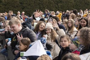 Młodzież zgromadzona pod sceną, macha do obiektywu.