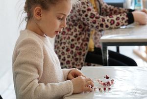 Dzieci wykonujące serce z koralików podczas warsztatów z metaloplstyki