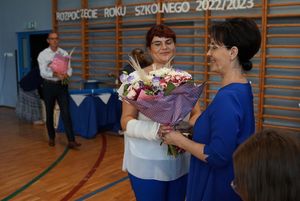 Zdjęcie przedstawia wręczenie kwiatów