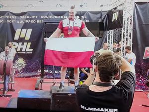 Dennis Sitek na podium z flagą Polski
