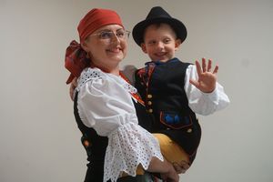 Kobieta w stroju ludowym z dzieckiem na ręce