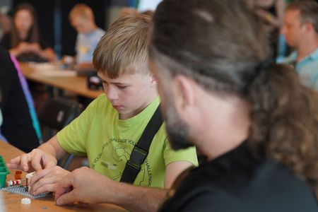 Zbliżenie na chłopca, który w skupieniu składa klocki