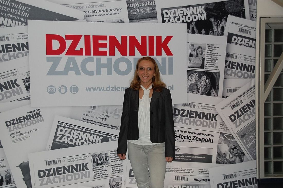 Strażniczka miejska stoi na tle ścianki z gazet Dziennik Zachodni