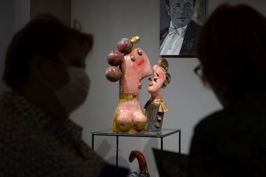 Dwie osoby, a w tle praca artysty - ceramiczna figurka.