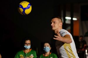 Siatkarz posyła do publiczności podpisaną piłkę.