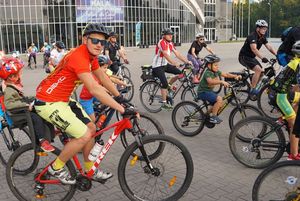 Grupa rowerzystów przed halą widowiskowo-sportową