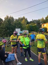 Grupa ludzi w rowerowych kaskach stoi obok siebie