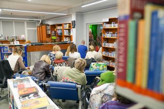 Kobiety w zewnetrznej sali słuchają Kieżuna 