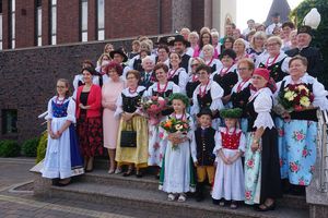 Zdjęcie zbiorowe pań z koła gospodyń wiejskich z prezydent miasta Anną Hetman przed kościołem w Bziu