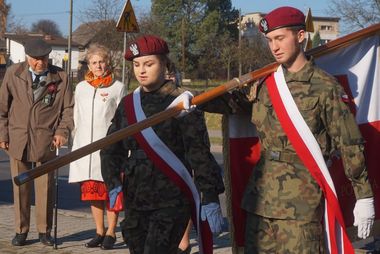 Młodzież idąca z pocztem sztandarowym, w tle - kombatanci