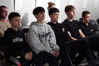 1. Młodzież siedzi na krzesłach patrząc przed siebie.