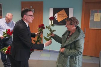 Prezydent wręcza róże pani w holu kina centrum z okazji dnia kobiet