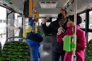 Widok na wnętrze autobusu z pasażerami.