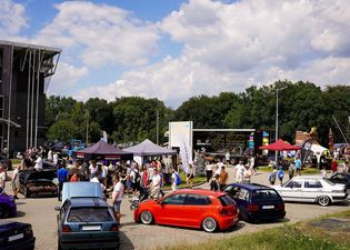 ekspozycja otwarta na wystawe samochodów i tłum ludzi pomiedzy nimi