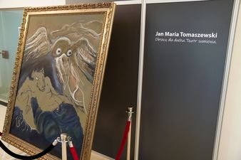 Obraz obok tablica z napisem: Jan Maria Tomaszewski, Obrazy dla ducha. Teatr sumienia