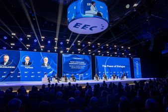 Ujęcie szerokie publiczność z tyłu, na scenie paneliści siedzą na fotelach