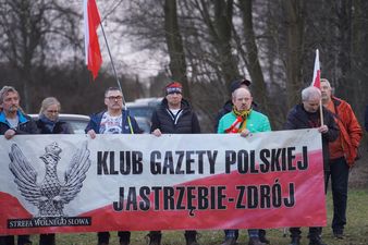 Mężczyźni z polskimi flagami trzymający baner z napisem Strefa Wolnego Słowa Gazety Polskiej Jastrzębie-Zdrój