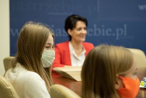 Spotkanie - uczestnicy siedzą przy stole i rozmawiają.