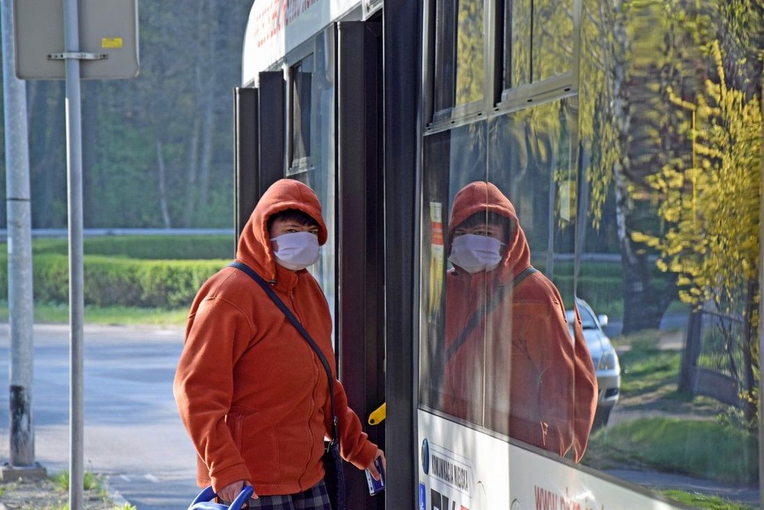 Osoba korzystającą z komunikacji miejskiej w maseczce zasłaniającej usta i nos