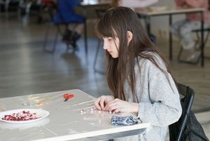 Dzieci wykonujące serce z koralików podczas warsztatów z metaloplstyki