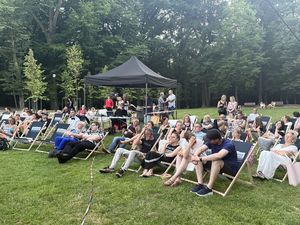 Ujęcie z przodu, ludzie na leżakach z tyłu czarny namiot ze sprzętem elektronicznym